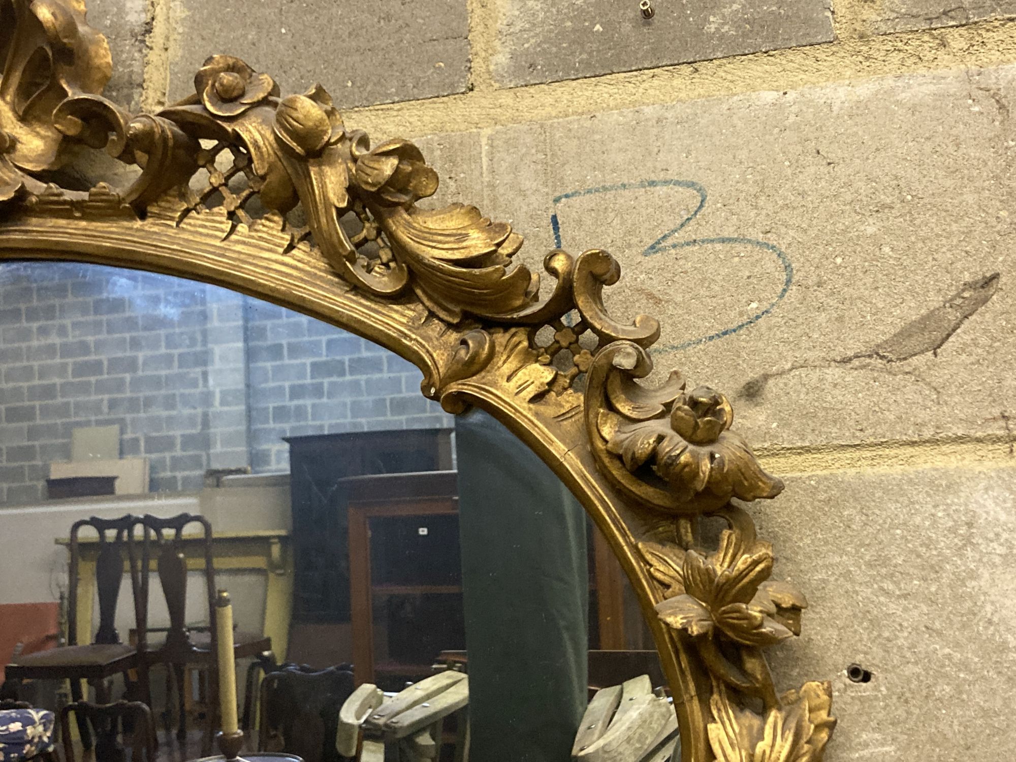 A Victorian ornate gilt oval wall mirror, width 110cm height 100cm